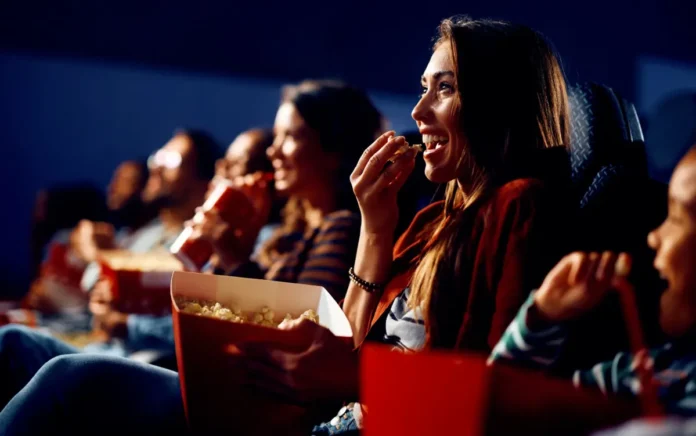 In foto il pubblico di un cinema che mangia pop-con allegramente.